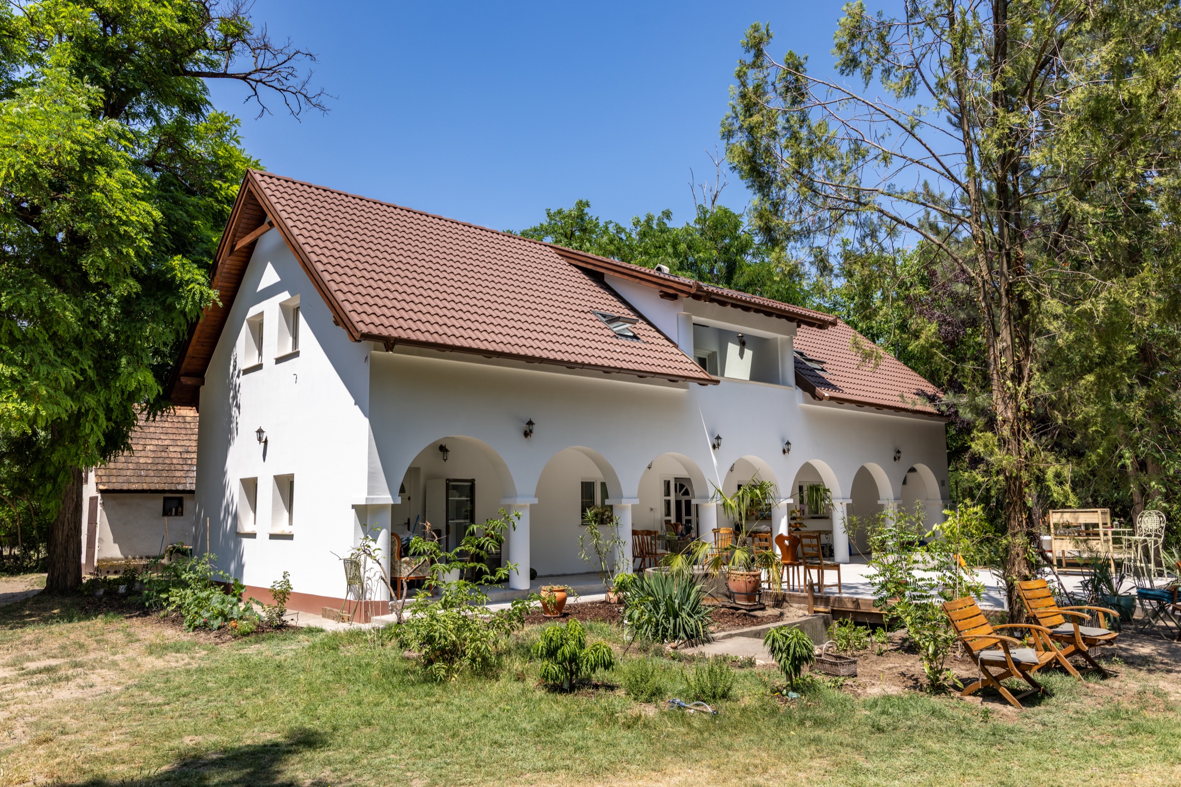 Haupthaus des Akazienhofs mit überdachter Arkade und Garten
