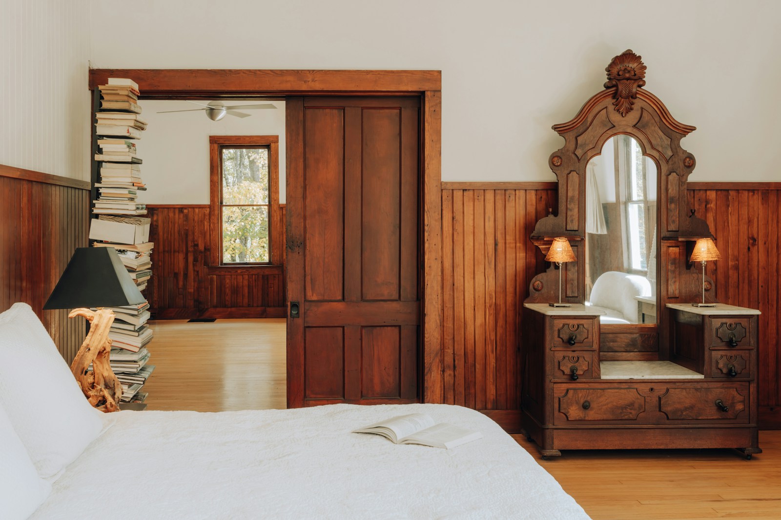 Gemütliches rustikales Gästezimmer mit Holzvertäfelung und antiker Kommode